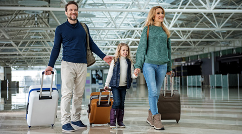 Family walking with bags at airport